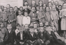 Učenci pred šolskim poslopjem z učiteljem Avgustom Kričikom leta 1930. Hrani Osnovna šola Jožeta Gorjupa Kostanjevica na Krki