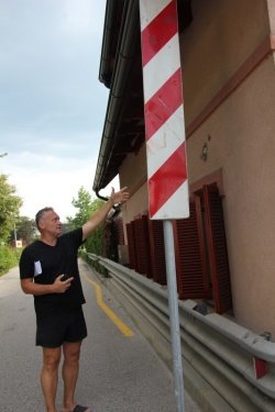 Igor Lešnjak kaže poškodbo na fasadi in prometni znak, ki so ga vozila že nekajkrat podrla.
