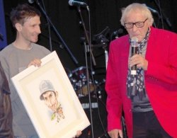 Robert Kranjec se je razveselil darila iz rok Tofa – svoje karikature.