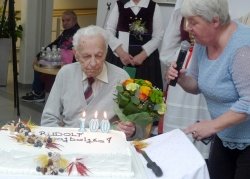 Torta in šopek za stoletnika Rudija, zraven pa Mateja Zelić iz doma