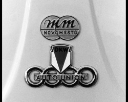 Logotip Motomontaže na motornem pokrovu kombija DKW, pod njim znak  DKW-AUTO UNION, predhodnika današnjih osebnih avtomobilov Audi