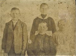    Fotografija osirotelih otrok iz kmetije Vučji ogrizek s skrbnico teto Magdo » Šnajderko « (osebni arhiv BG)