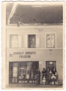 Frizerski salon z napisom na fasadi Rudolf Kreutz, Friseur; pred salonom stoji družina Kreutz, 1943 (Iz arhiva PMB)