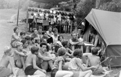 Prizor s tabora leta 1959: taborniki so zbrani pred šotorom Marjana  Moškona - Črnega soma, med drugim tudi nekdanjega novinarja in urednika  Dolenjskega lista.