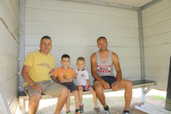 Na vrtičku pod nadstreškom (z leve) Aldin Hasančić, njegov sin Almin, sin Alana Karahasanovića Rejan in Alan Karahasanović