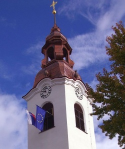 Na zvoniku je obnovljena tudi ura, z okna pa visita slovenska in evropska zastava. (Foto: L. M.)